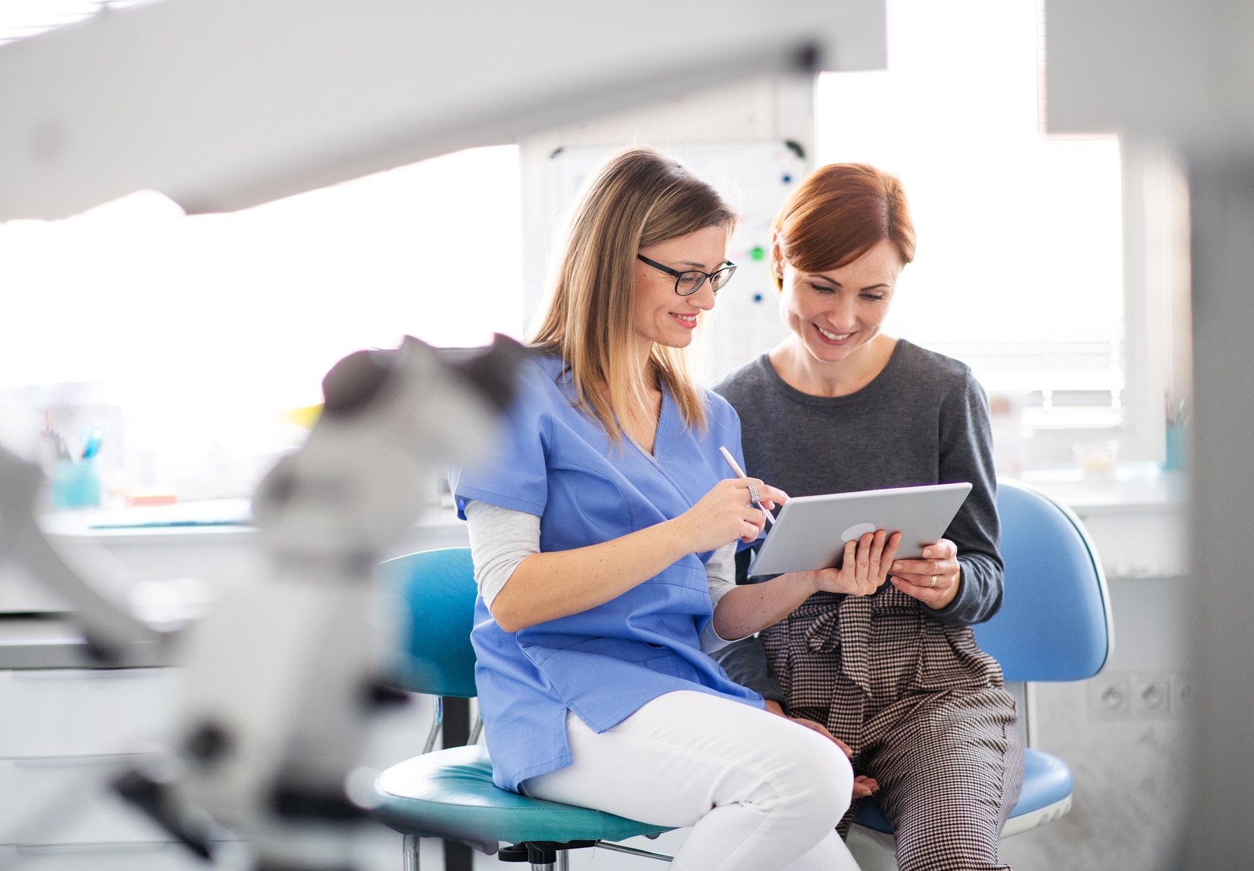 A dentist talking to woman in dentist surgery, a dental check-up.